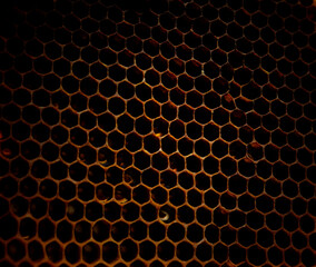 Dark Hexagonal textured honeycomb background close-up. Black broun yellow background. Agricultural concept