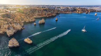 Aerial view of the beautiful paradise beaches of Camilo and Dona Anna, Lagos area. Tourist boats and ships entertain tourists on summer vacations.