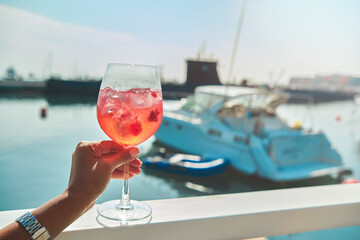 Woman hand holding cup wine the beginning of summer, summer concept