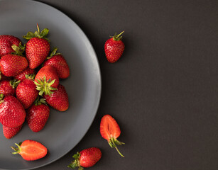 Fresh sweet strawberries on dark background with space for text on the right. Top view