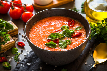 Tomato soup or gazpacho at black table. Summer cold vegan food.