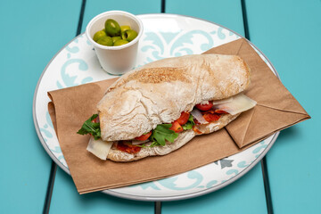 Bread sandwich with chorizo, cheese and herbs. Green azeitones. Indian food. Close-up.