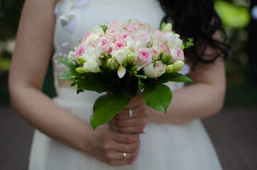 wedding bouquet with pink roses in the hands of the bride