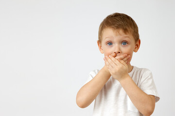 Child restrains emotion by covering his mouth with his hands, so as not to cry out from the horror...
