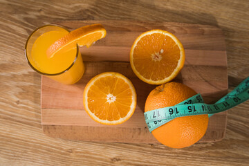 orange on the table, measuring tape and orange juice © Fantastic
