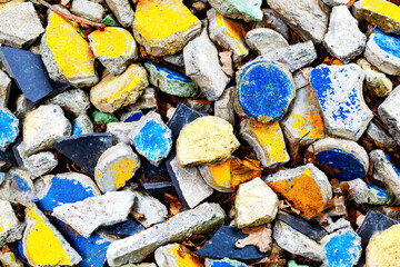 Abstract natural textured background made of multicolored stones. Colorful stone background. Multicolored concrete. Yellow, gray, and blue fragments of concrete.