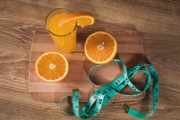 orange on the table, measuring tape and orange juice © Fantastic