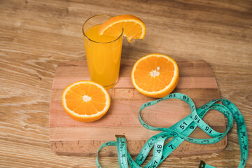 orange on the table, measuring tape and orange juice © Fantastic