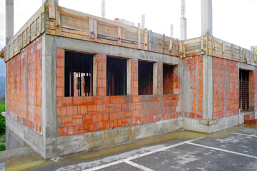Unfinished construction of a new apartment building. red brick house wall under construction