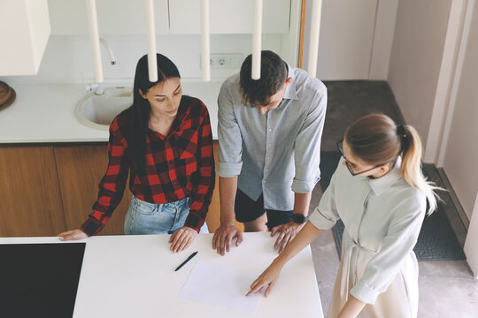 Top view of professional real estate agent acquaints buyers with the purchase agreement