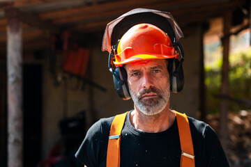 Serious lumberjack in safety gear at sawmill 
