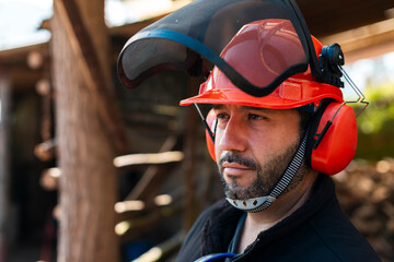 Satisfied lumberjack in safety gear at sawmill 