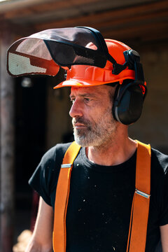 Content lumberjack in safety gear at sawmill 