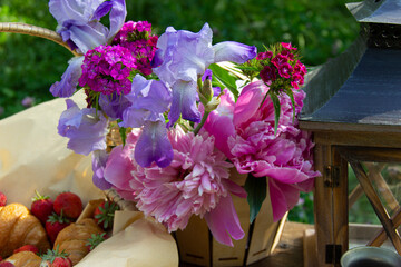 fresh flowers are placed on the table next to the lamp .croissant and strawberries