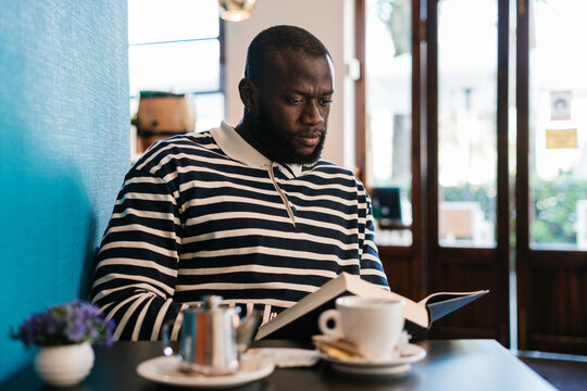 African Man Reading in a Cafeteria