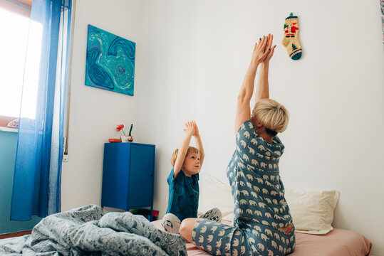 Mother and son stratching in bed in the morning