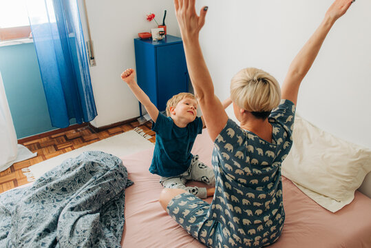 Mother and son stratching in bed in the morning
