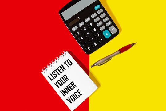 Listen to your inner voice - the text is written on a notebook that lies on a red and yellow background