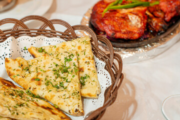 Closeup of wicker basket with sliced garlic bread on the table of a hindu restaurant