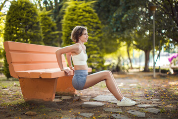 Exercise on the bench outdoor. Woman training in the park. Fitness and healthcare concept