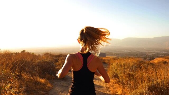 Following Female Trail Runner at Sunset 4K