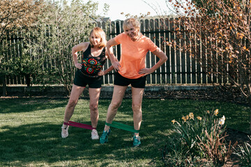 Two active senior women go in for sports using sports elastic bands for exercise, healthy lifestyle concept