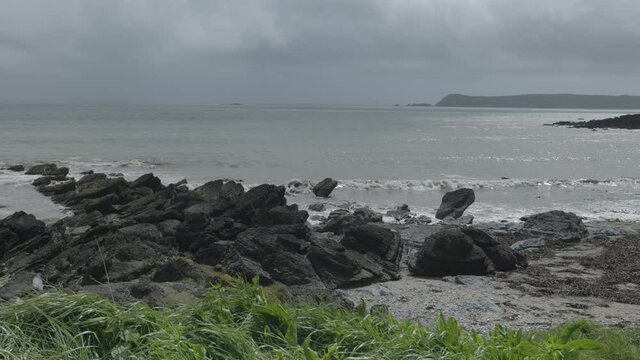 rocks in the foreground and oleja from an Irish beach on the Cooper Coast, Ireland. near the town of Dungarvan. 