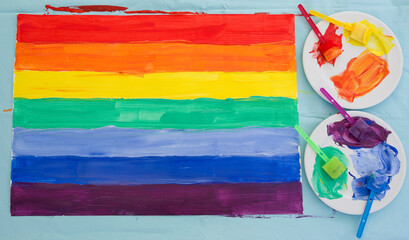 flag in the colors of the rainbow, as support for the minority community is painted with paints casually, LGBT pride, holiday