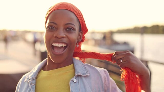 Beautiful young woman putting on head wrap
