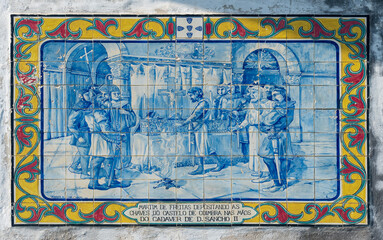 Velho painel de azulejos com uma cena de um momento da história portuguesa