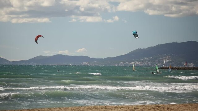 Extreme water sports, people are kitesurfing in the ocean near the beach, Spain