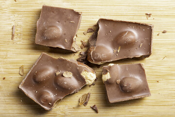 Tasty dark chocolate with hazelnuts on a wooden board. A delicious dessert favorite by children and adults.