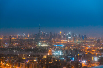Fototapeta premium Night Aerial View Of Dubai Cityscape Skyline. Top View Skyline Cityscape City In Night Illuminations. Dubai, United Arab Emirates