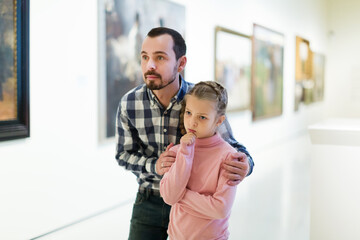 Fototapeta premium Glad father and daughter looking at expositions in museum