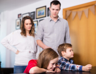 Obraz premium Father and mother telling off their son and daughter for disobedience