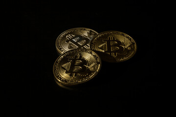 TABLE BACKED BITCOIN COINS ON BLACK BACKGROUND