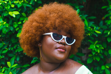portrait of a woman in white an Afro and green outfit.