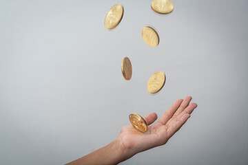 BITCOIN COINS FALLING INTO HANDS ON WHITE BACKGROUND