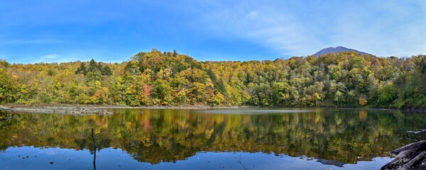 ちょうど見頃の紅葉に囲まれた半月湖のパノラマ情景＠北海道
