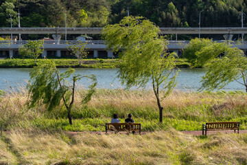 강가 앞에서 앉아 쉬고있는 부부