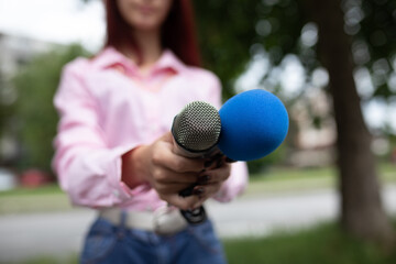 What is your storry? Journalist at news conference, writing notes, holding microphones