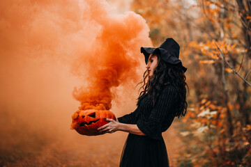Orange smoke from pumpkin holding girl in witch costume