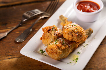 Fried lamb chops in parmesan batter with tomato sauce