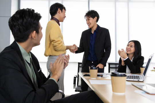 A group of multi-sex colleagues businesspeople, tomboy and transgender gay, working together with happy and intimate manner with laptop notebook computer in office