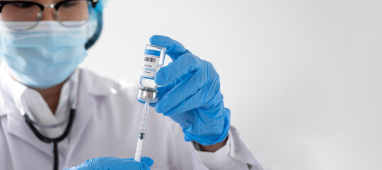 A female doctor is sucking COVID-19 vaccine from a hospital bottle, Medical and therapeutic Concept