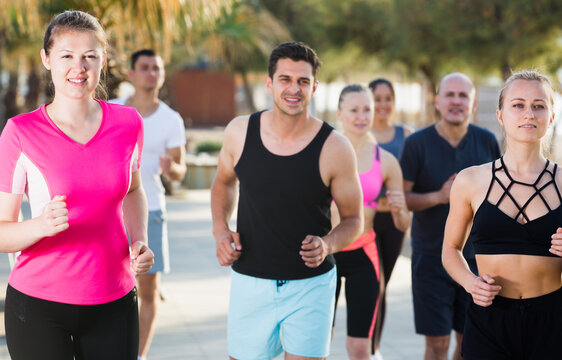 Active smiling people during running training in daytime