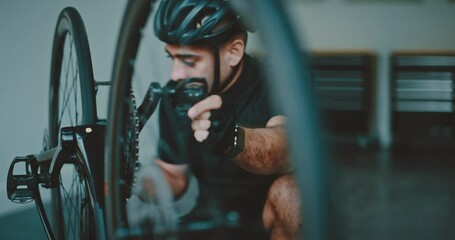 Athlete working on his bicycle in his garage, getting ready to go cycling, athletic healthy lifestyle