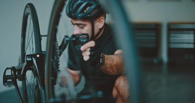 Athlete working on his bicycle in his garage, getting ready to go cycling, athletic healthy lifestyle
