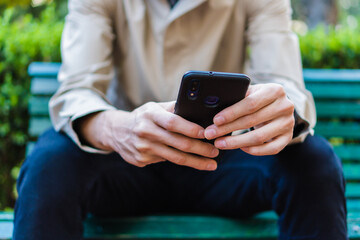 close up of hands with a smart cell phone in a city park, outside, clearing the mind