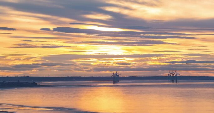 Redcar Wind Farm Time Lapse, Teesside, Towards South Gare, River Tees entrance. Golden sun setting at sunset.